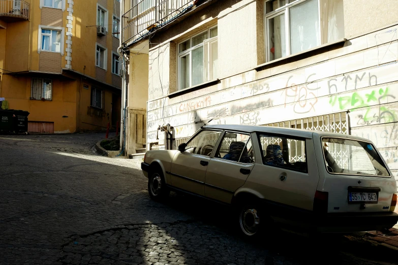 a small car is parked on the side of the street