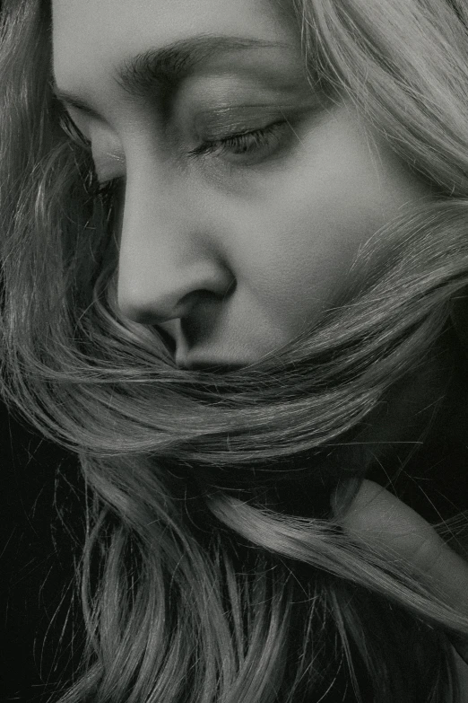 a close - up of the face and shoulders of a woman with hair flowing out and curled in