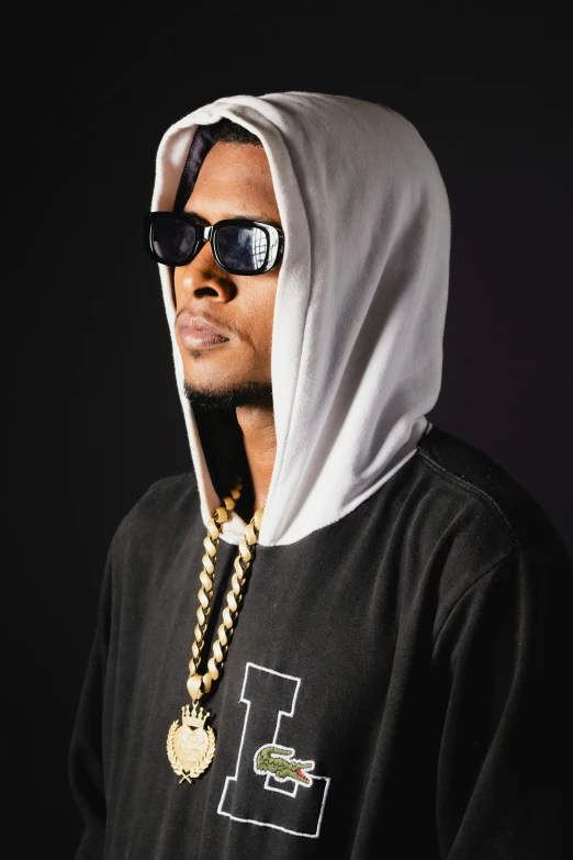 a man is dressed in a hooded sweatshirt and sunglasses