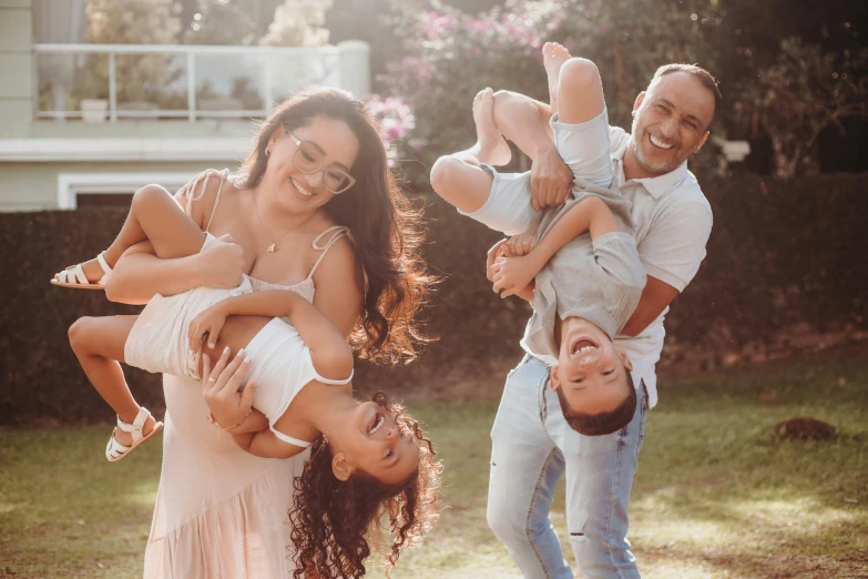 three adults and two children playing in the yard