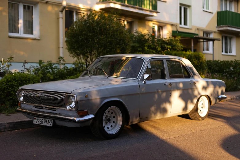 a classic car sitting on the side of a street