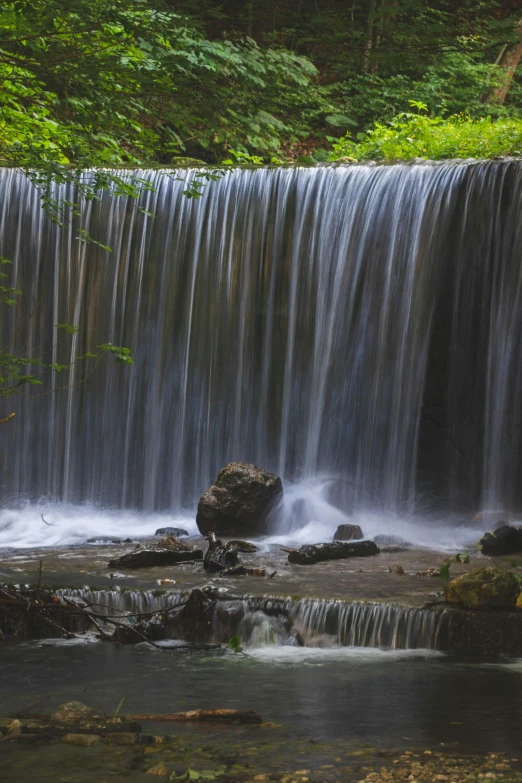 the small waterfall has lots of water tumbling over it