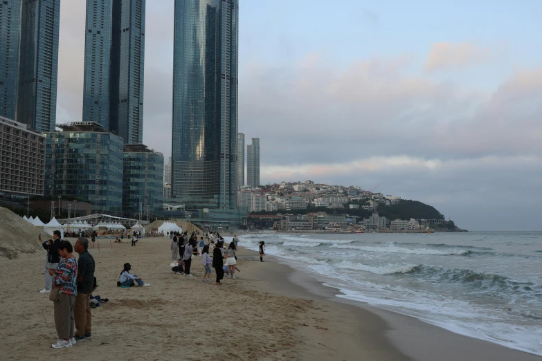 people on the beach in front of high rise buildings