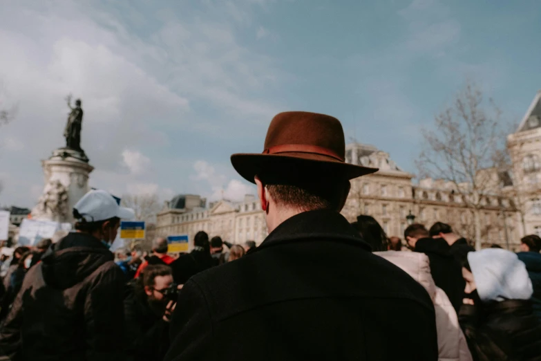 a person wearing a brown hat standing in a crowd