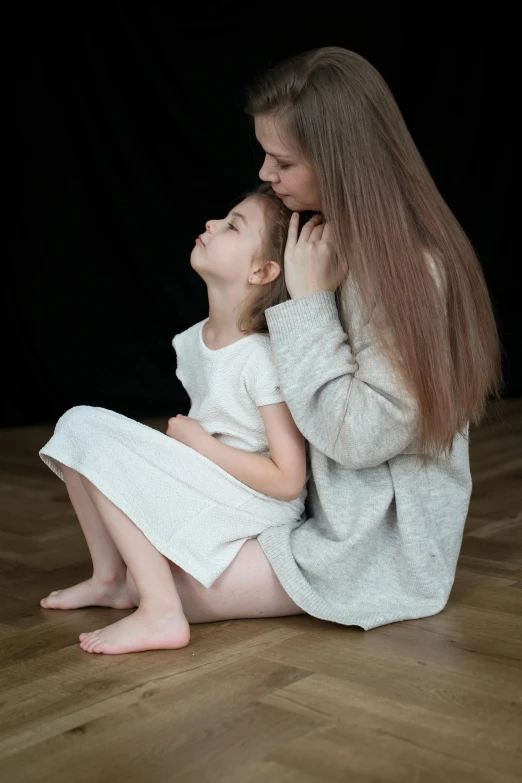 a  sitting on the ground next to an older woman