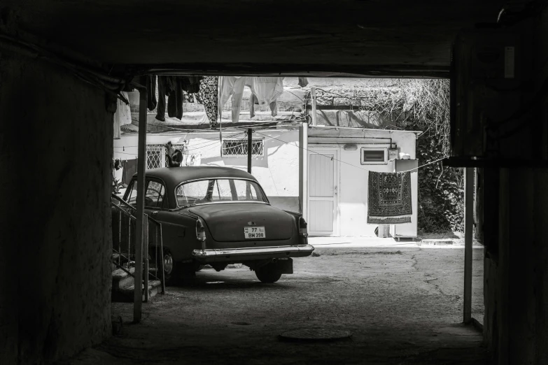 a old car parked in the parking space of a garage