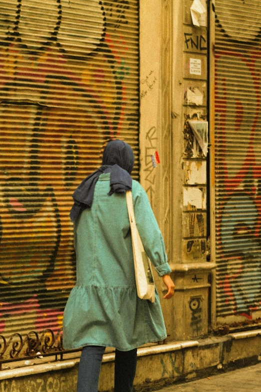 a woman walking down a sidewalk past a building