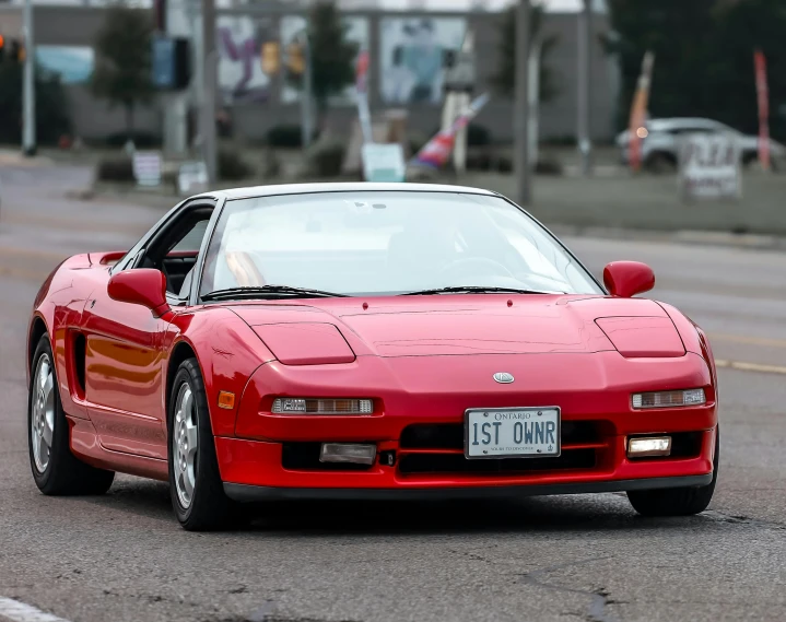 a red sports car sits parked on a street