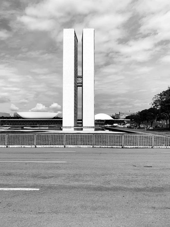 black and white pograph of a monument with the two towers of a building in front of them