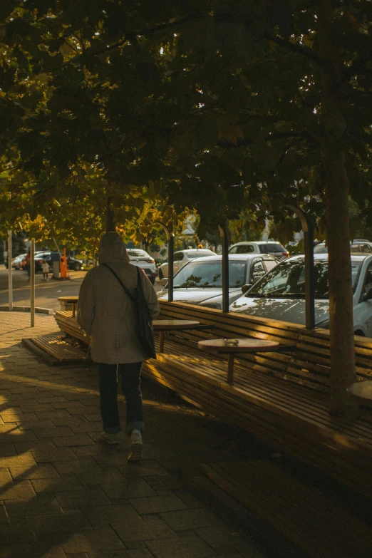 someone is walking in front of many parked cars