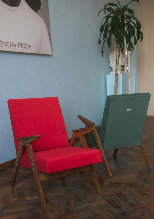 a red chair and two green recliners are sitting together in a room