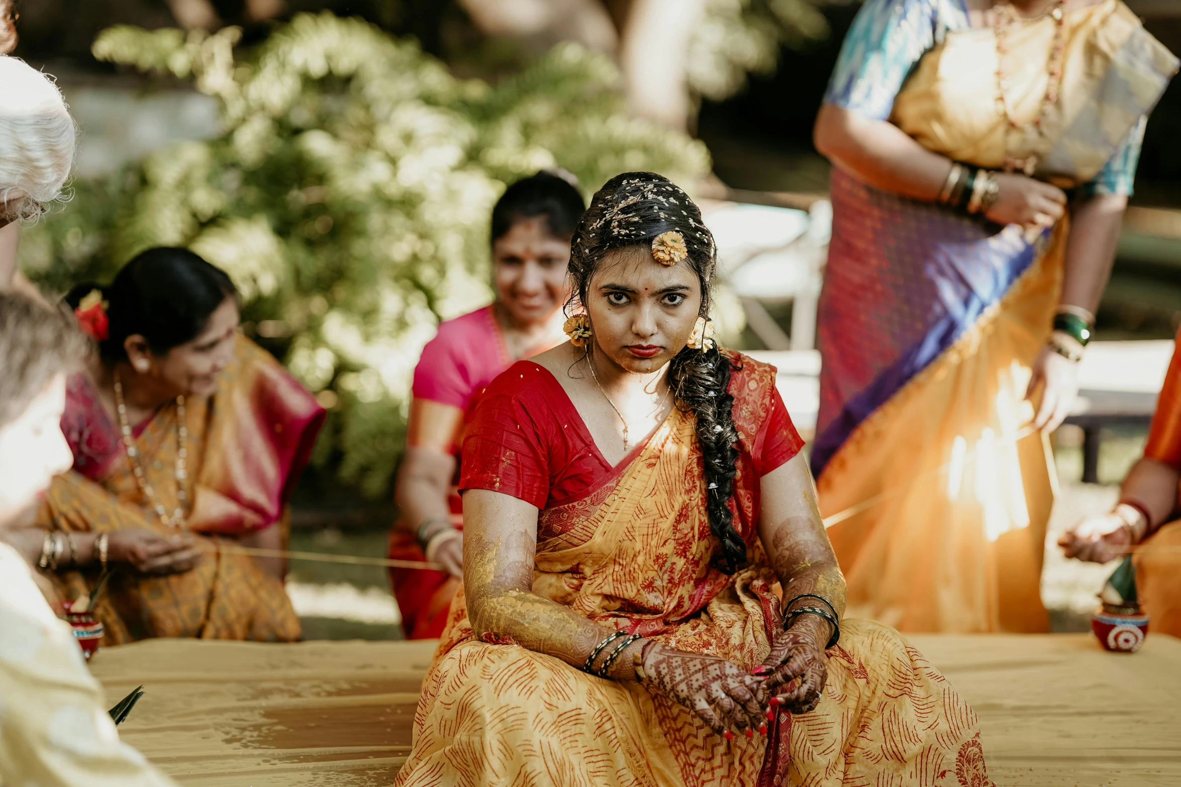 a woman sitting on the ground at a hindu wedding