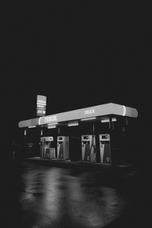 a dark po of an oil station with some gas pumps