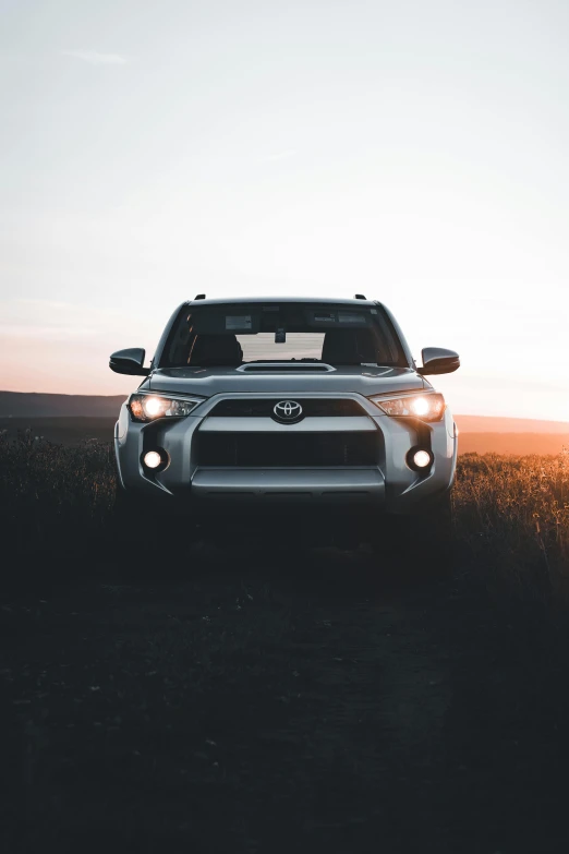 the front end of a silver toyota four - door suv in a field