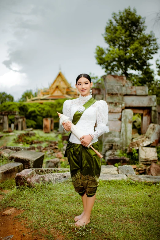 a woman is posing in the ruins of a temple