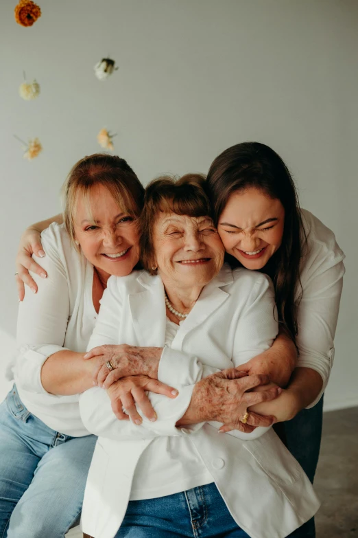 three people hugging one another with a white background