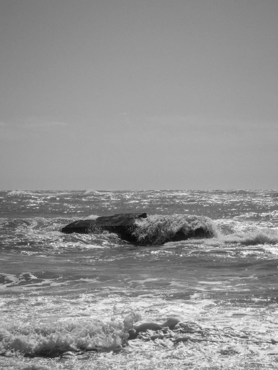 two people stand on the beach watching the waves