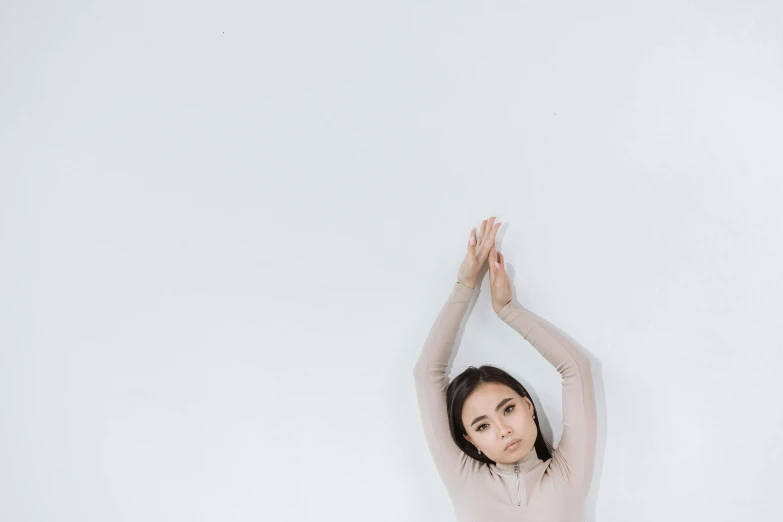 a woman is doing a yoga pose with her hands behind her head