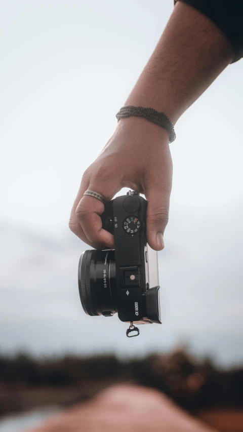 a man holding up a camera in the air