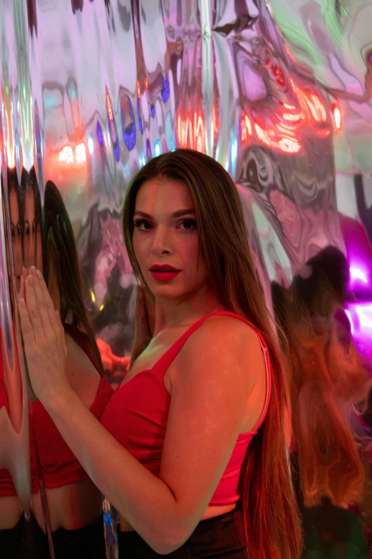 a woman in a red top holding a giant mirror