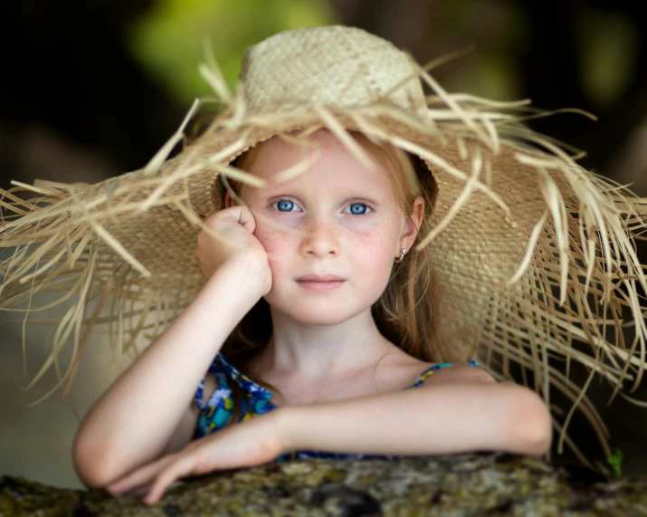 a child wearing a straw hat is looking into the distance