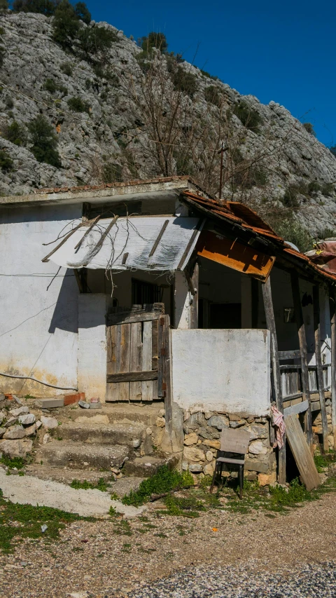 an old house sitting in the middle of a rocky field