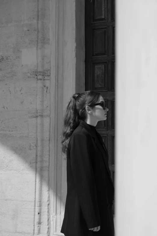 a person wearing glasses walking towards a wall