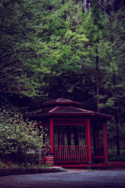 a small red structure with trees in the background