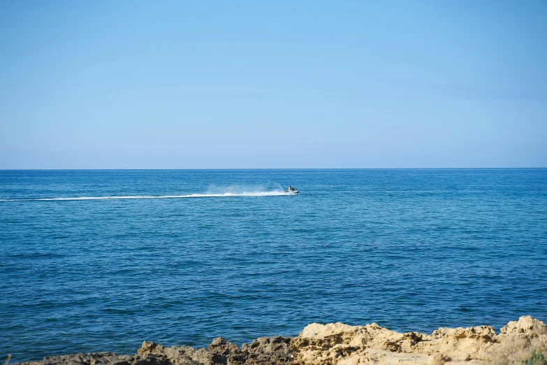 a boat is heading in towards the horizon and the waves