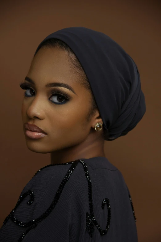 a woman in black dress and a blue head wrap