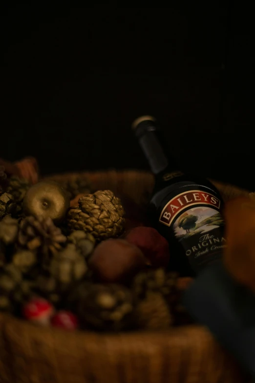 the fruit is in the wooden bowl with the bottle