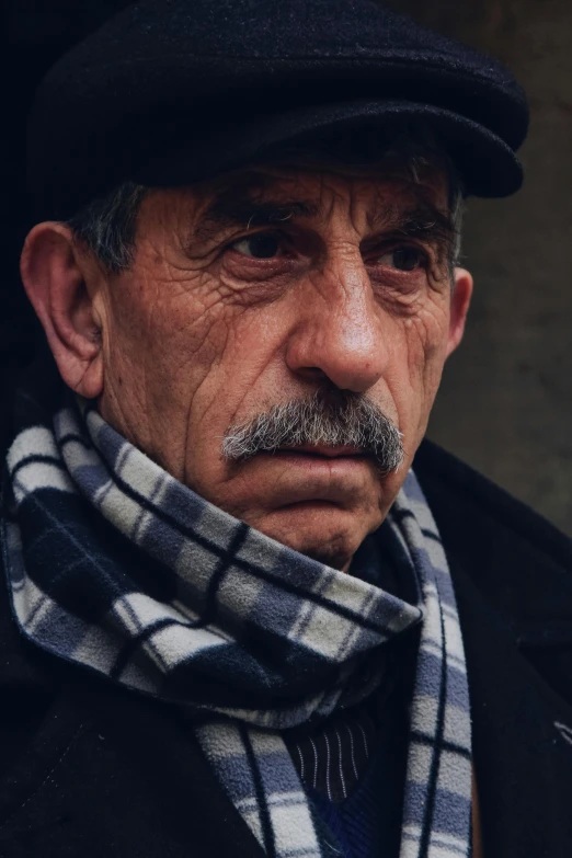 an old man wearing a cap and scarf