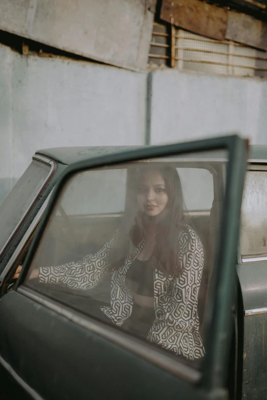 woman with hair hanging out window sitting in car