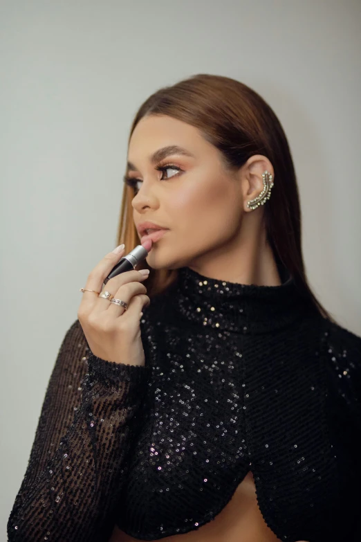 a young woman with large  in a black dress holding a cigarette