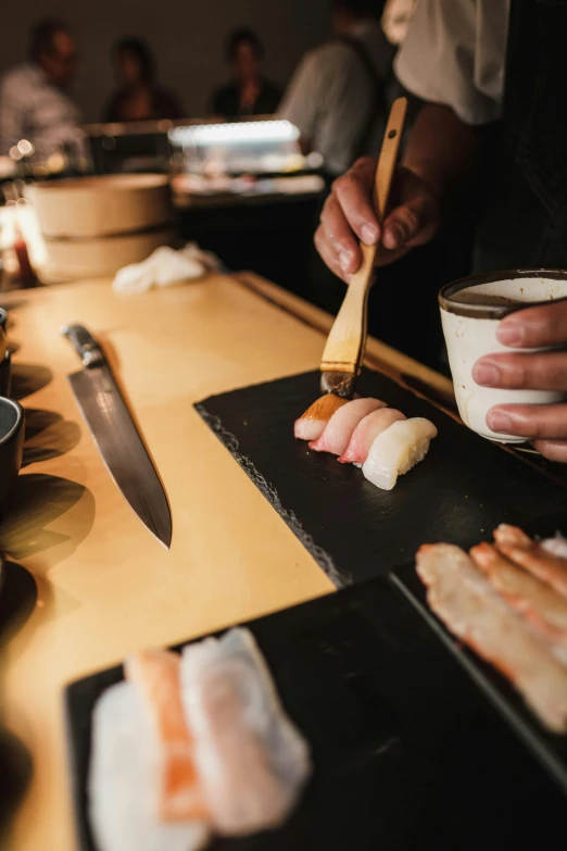 a sushi set on a long table with chopsticks and plates