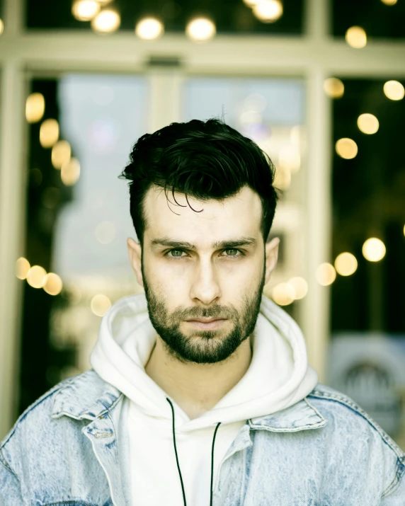 a young man in white hoodie looking straight ahead