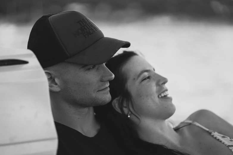 a woman and man sitting next to each other wearing hats