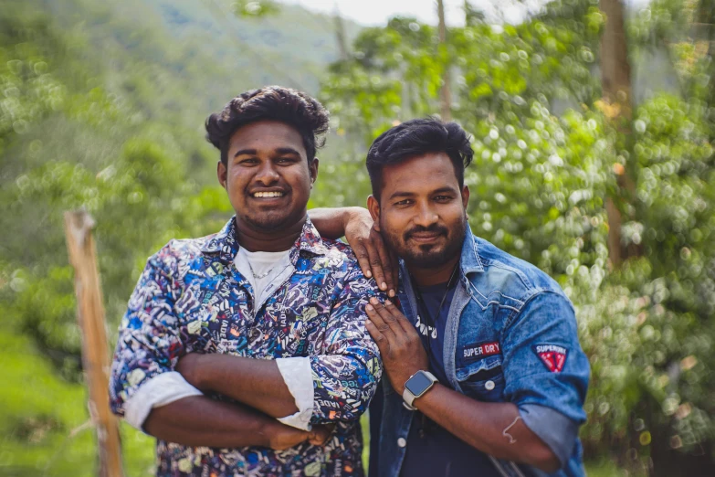 two men are standing together and smiling