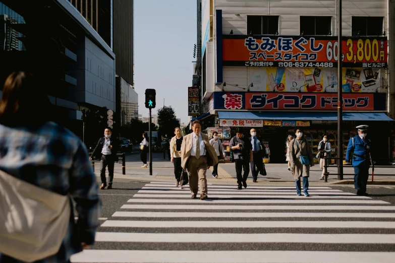 many people are crossing the street at the crosswalk