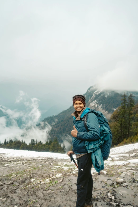 a man standing on the side of a snow covered mountain