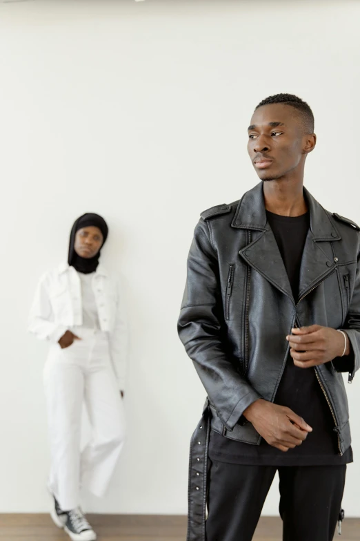 a black male in a black shirt a woman in a white suit