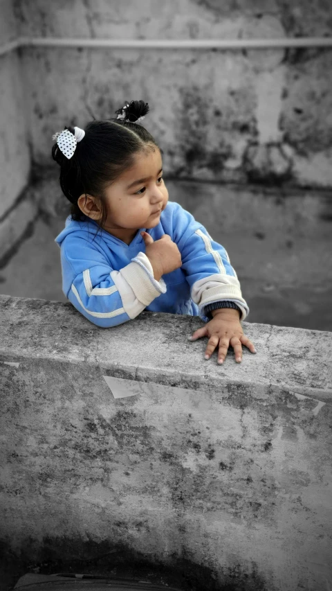 a young child laying on the edge of a cement ledge