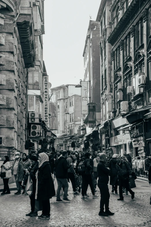 several people walk through the middle of a brick road