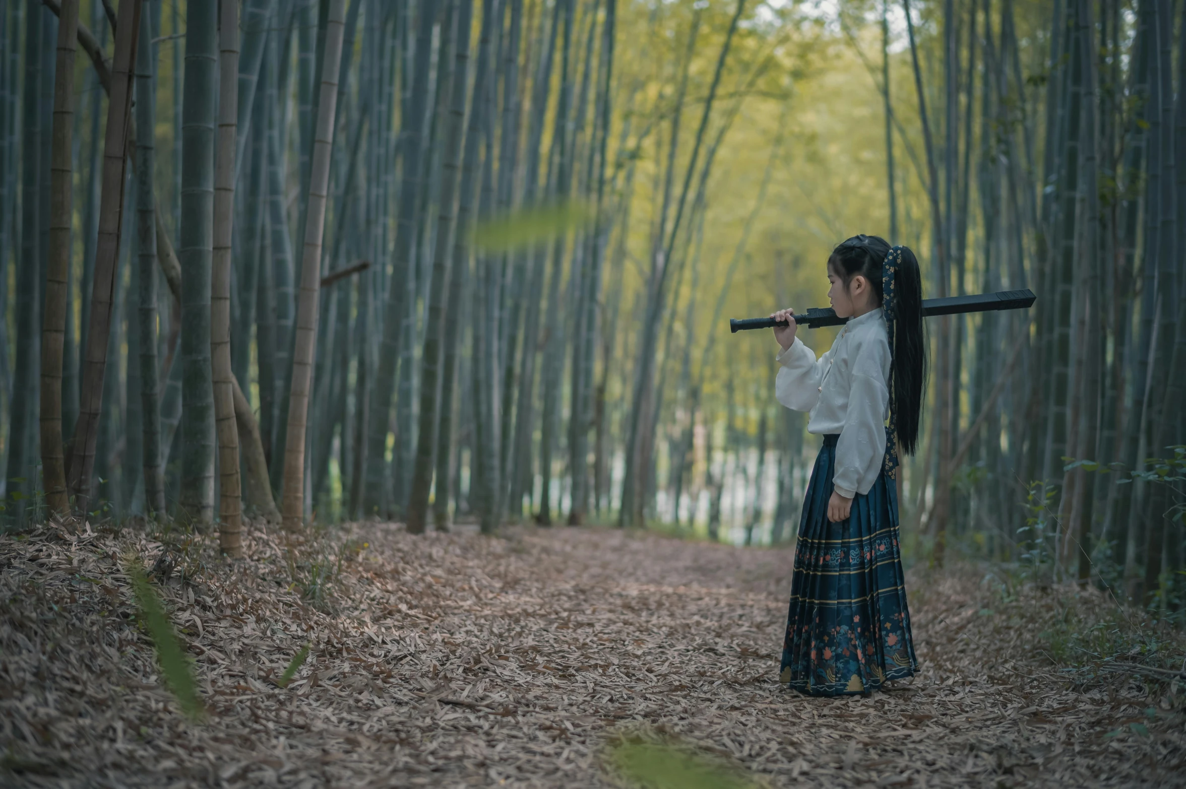 woman with a stick walking down a dirt path