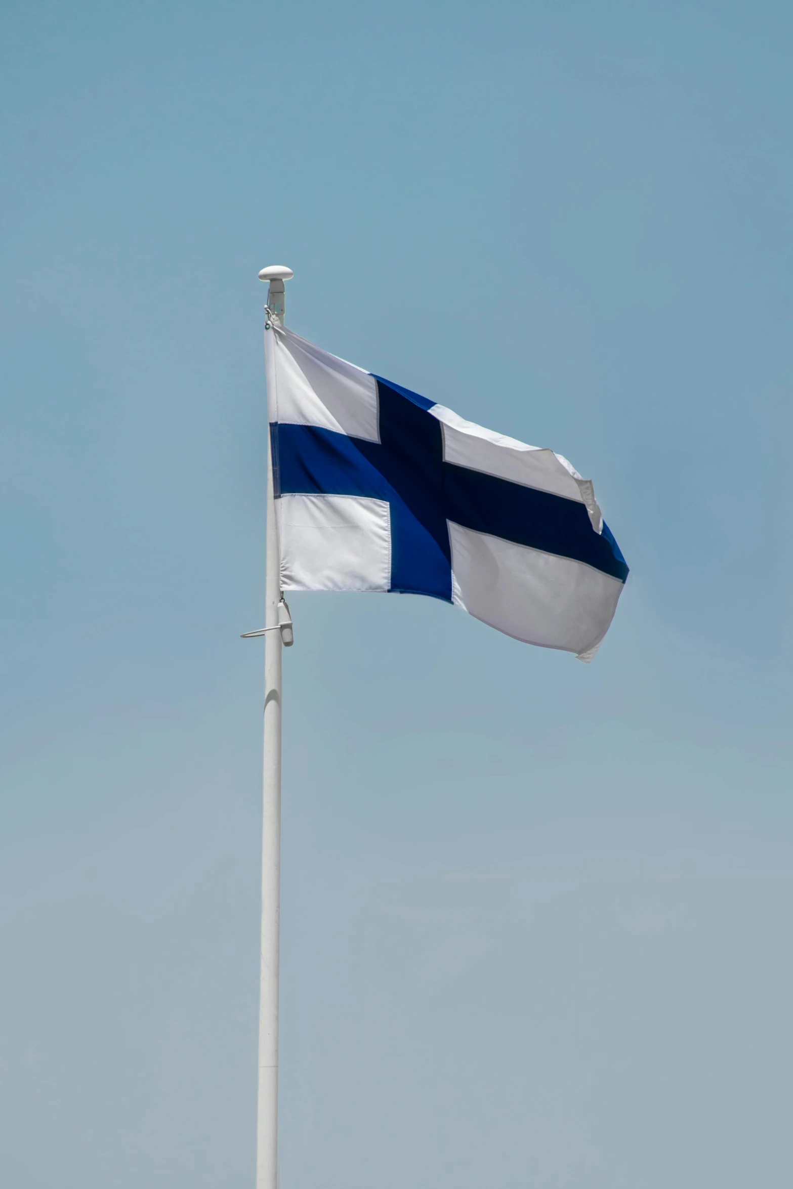 a tall flag pole is being flown by the wind