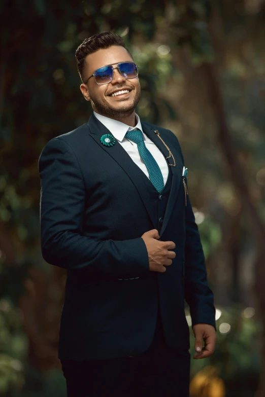 a man wearing sunglasses in a suit and green tie