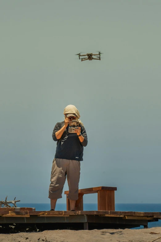 a man taking a po on a beach with a small plane