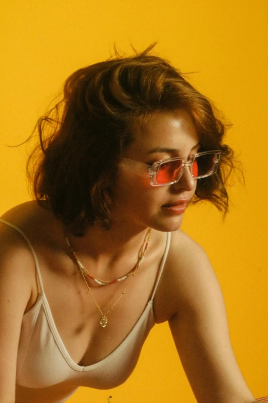 a beautiful young woman wearing red glasses and sitting down