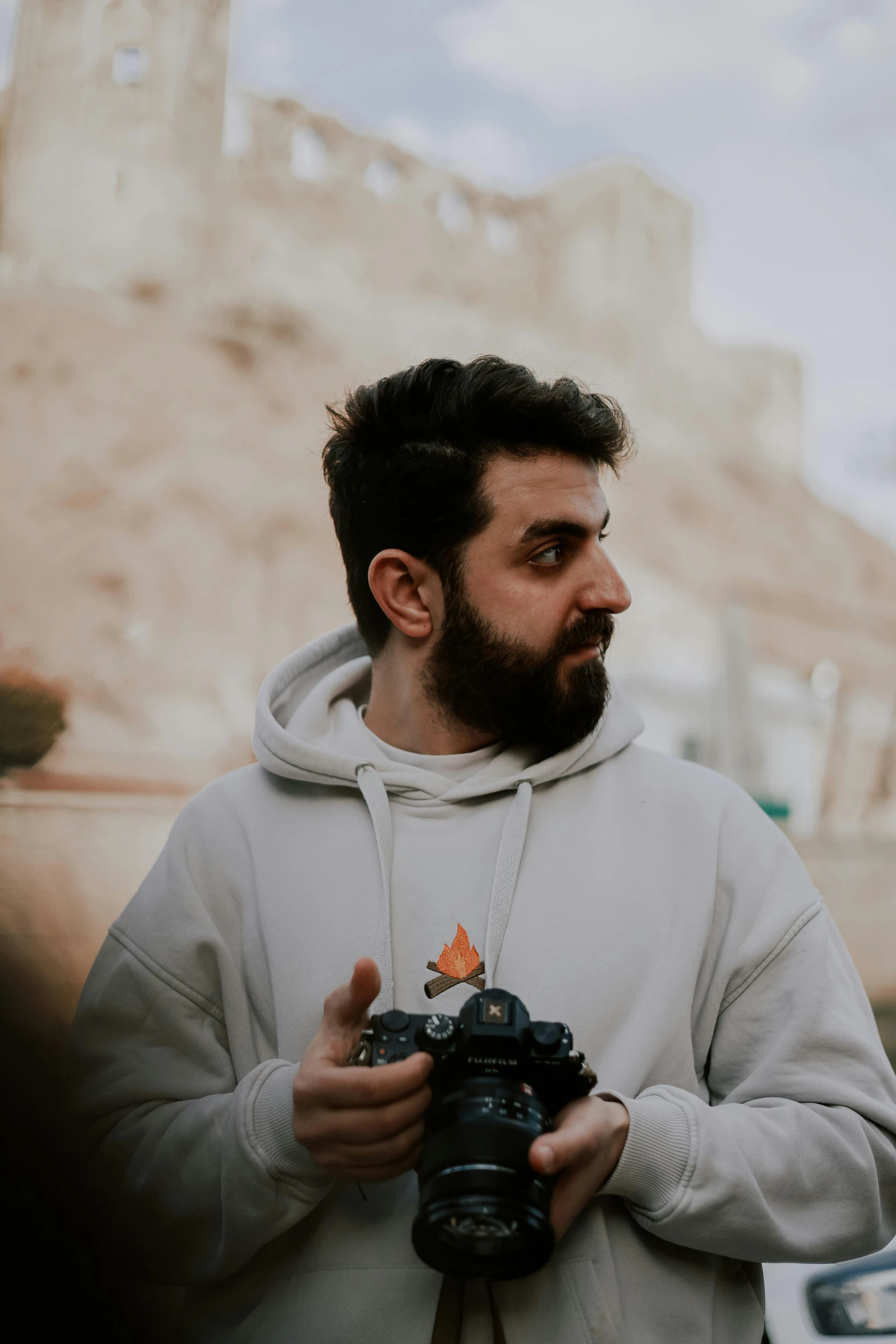 man with beard standing near camera taking pictures