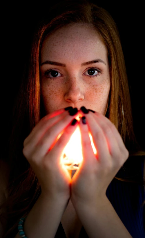 a young woman is putting light between her hands